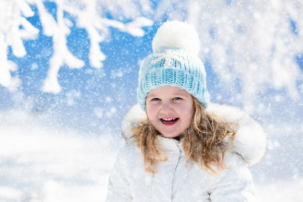 Enfant s'amusant dans un parc d'hiver enneigé
 - Photo, image