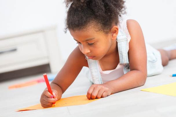 Дошкільна дівчинка малює на підлозі
 - Фото, зображення