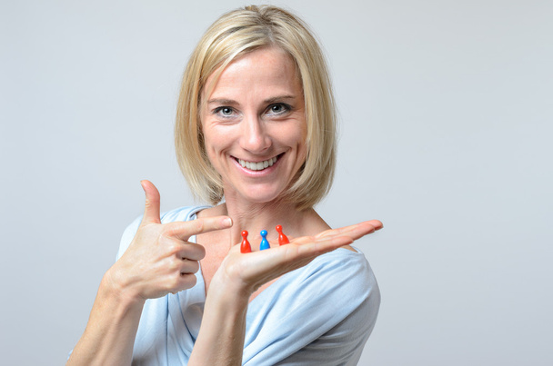 Gleeful woman pointing to three meeples - Photo, Image