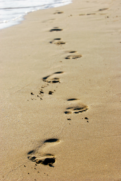 Jalanjälkiä tyhjällä hiekkarannalla
 - Valokuva, kuva