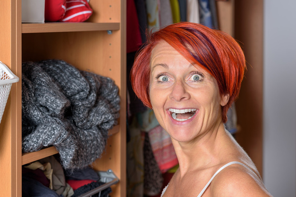 Surprised Middle Aged Woman in front of her wardrobe - Photo, Image