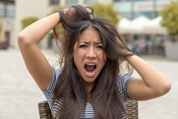 Verärgerte junge Frau reißt sich an den Haaren - Foto, Bild