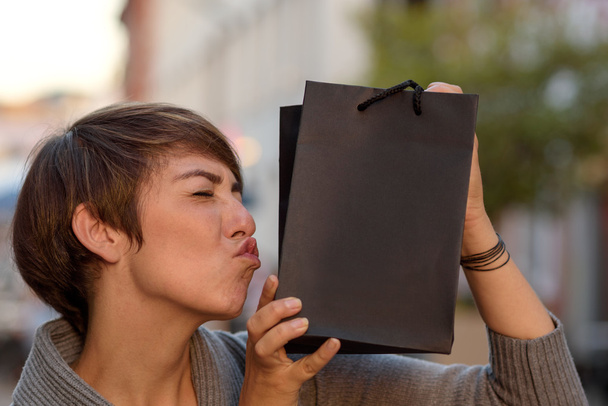 Задоволений покупець цілує її бутік сумку
 - Фото, зображення