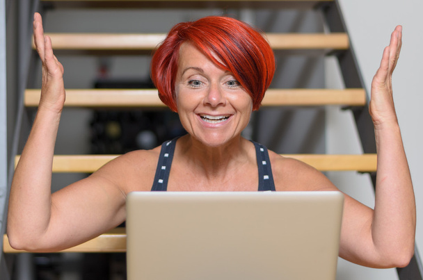 Heureuse femme adulte avec ordinateur portable levant les bras
 - Photo, image