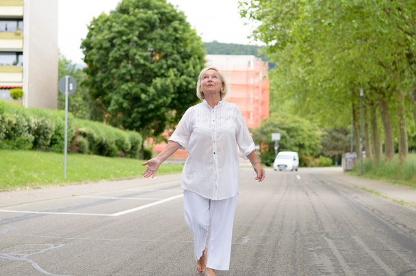 Ανώτερη γυναίκα σε όλα τα λευκά περπατώντας στο δρόμο - Φωτογραφία, εικόνα