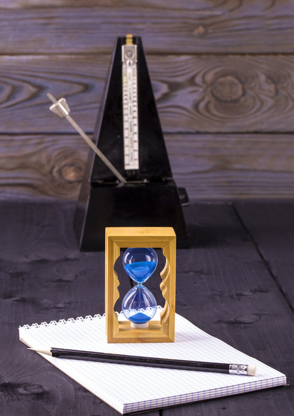 песочные часы, метроном и блокнот с карандашом
 - Фото, изображение