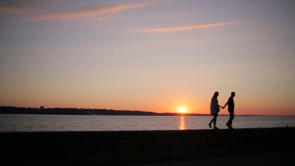 Paar spaziert bei Sonnenuntergang am Ufer des Flusses - Filmmaterial, Video