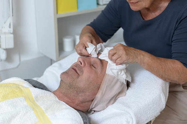 Man at beauty center receiving facial treatment - Photo, Image
