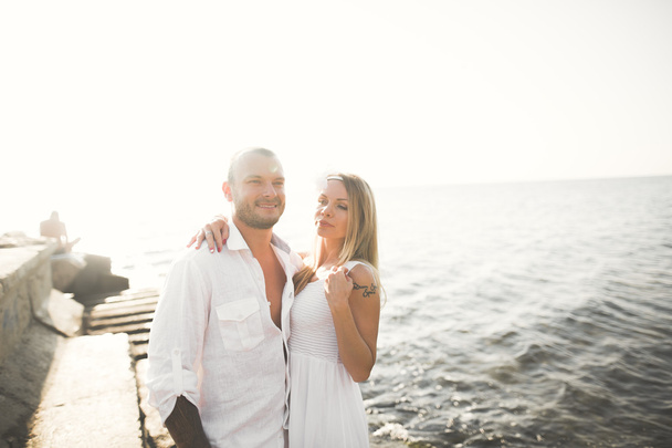happy just married young wedding couple celebrating and have fun at beautiful beach sunset - Fotografie, Obrázek
