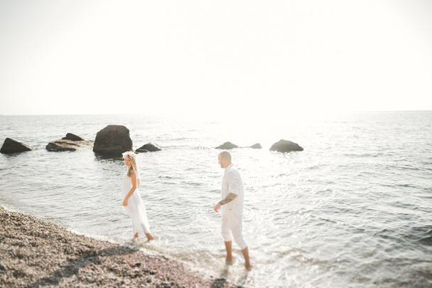 Happy romantic fashion couple in love have fun on beautiful sea at summer day - 写真・画像