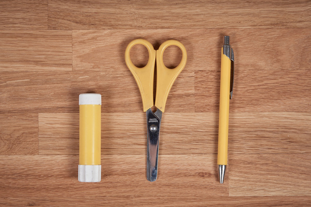 Colle, ciseaux et stylo sur une table en bois de chêne
 - Photo, image