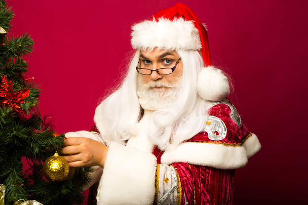Santa decorates Christmas tree - Fotoğraf, Görsel
