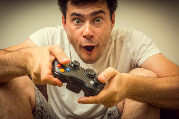 Emotional young addicted man playing video games - Photo, Image