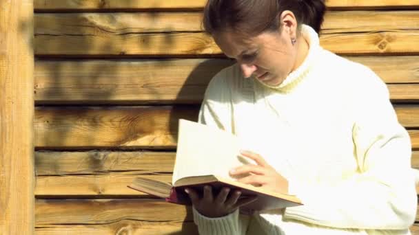 Красивая девушка читает книги на открытом воздухе
 - Кадры, видео