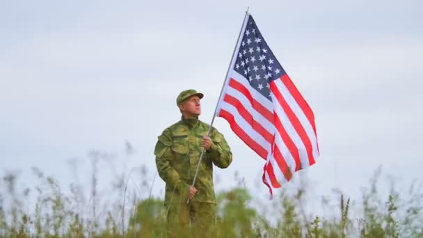   Αμερικανός στρατιώτης στο πεδίο κατά σημαία και γαλάζιο ουρανό. 4k 3840 x 2160 - Πλάνα, βίντεο