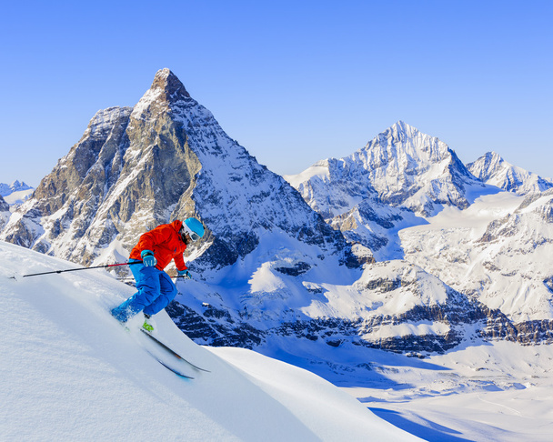 Esquiador esquiando cuesta abajo en las altas montañas en nieve en polvo fresco. Sn
 - Foto, imagen