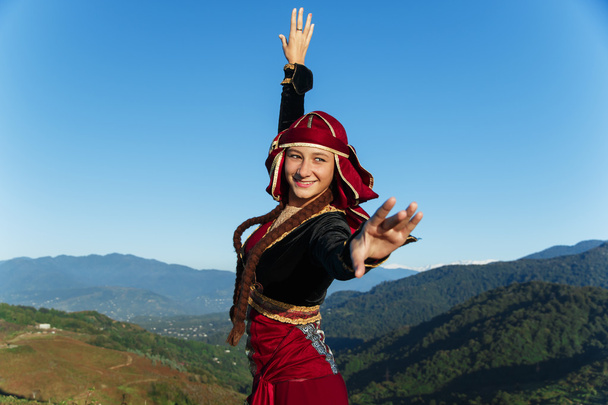 genç kadın Gürcü Ulusal giysileri dağlar açık havada yaz güneşli dans - Fotoğraf, Görsel