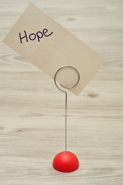 Um suporte de nota com uma base vermelha com um cartão com a palavra esperança
 - Foto, Imagem