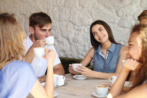 Happy friends drinking coffee in cafe - Фото, зображення