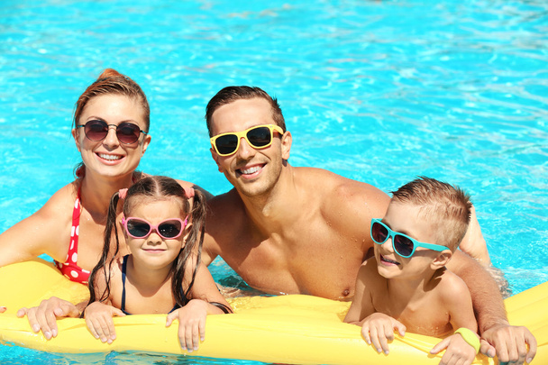 Family in swimming pool - 写真・画像