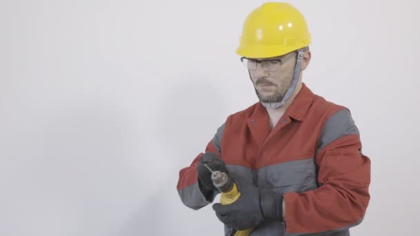 Worker preparing  a drilling machine for drilling - Filmati, video