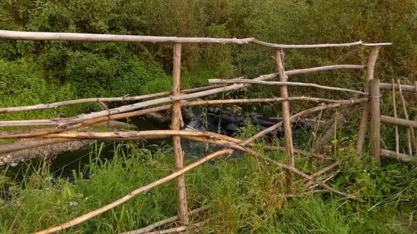 A patak partján a régi fából készült kerítés. - Felvétel, videó