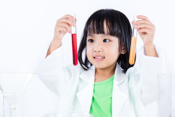 Smiling Asian Chinese Little Girl Examining Test Tube With Unifo - Foto, afbeelding