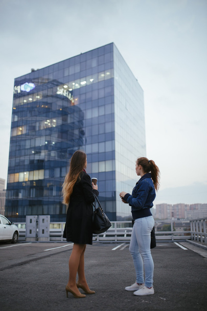 Two women looking on a big building, back view - Φωτογραφία, εικόνα