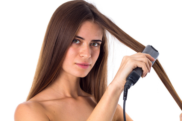 Woman using hair straightener - Fotoğraf, Görsel