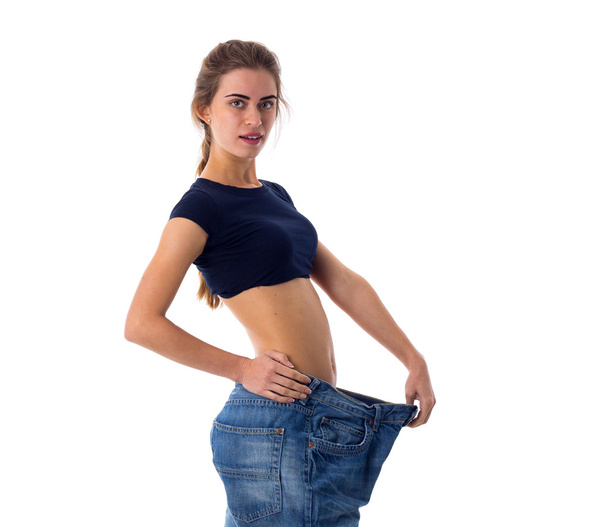 Woman wearing jeans of much bigger size - 写真・画像