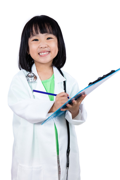 Smiling Asian Chinese Little Doctor Writting On Clip Board - 写真・画像