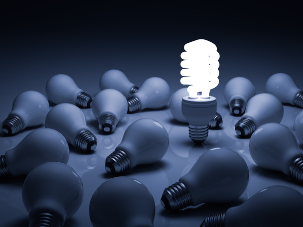 Lit compact fluorescent lightbulb standing amongst the unlit incandescent bulbs - Photo, Image