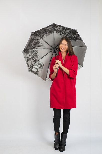 Porträt einer jungen Frau im Mantel mit Regenschirm auf weißem Hintergrund - Foto, Bild