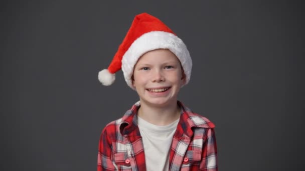Little boy in a christmas cap throwing up confetti - Imágenes, Vídeo