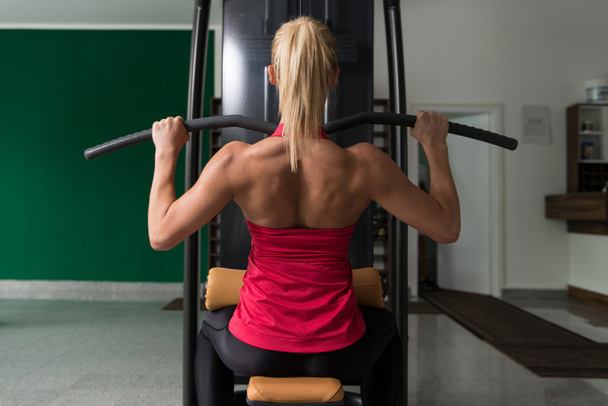 Fitness Woman Doing Exercise For Back On Machine - Foto, imagen