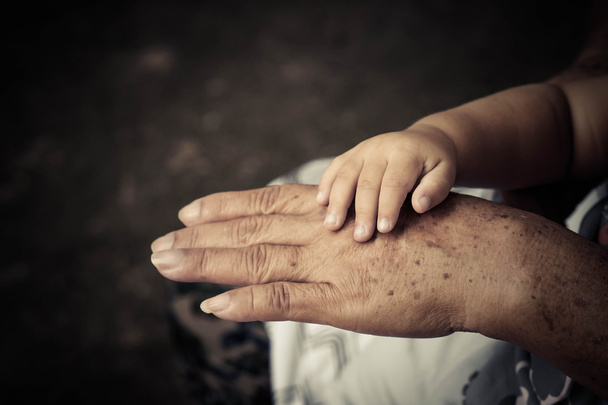 Vanha nainen käsi tilalla nuori vauva käsi
  - Valokuva, kuva