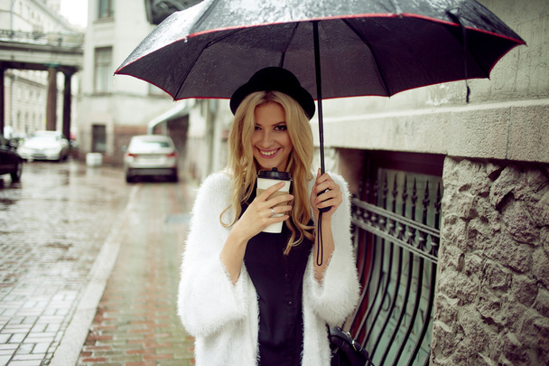 Cheerful woman in the street drinking morning coffee - Фото, изображение