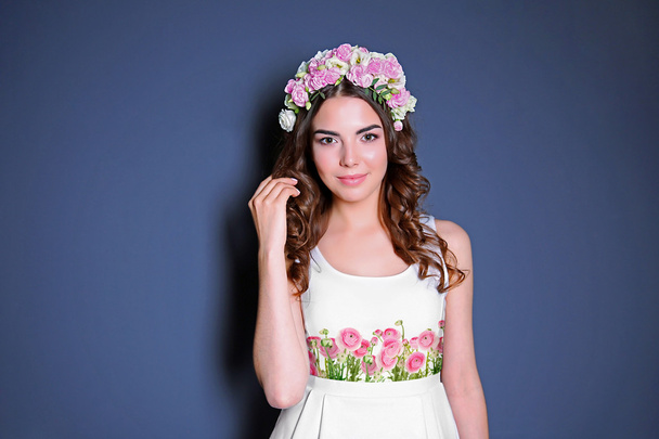 Young woman wearing dress with beautiful flower print and posing on color background. - Foto, Imagem