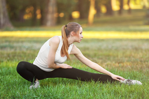 Young woman stretching outdoors - Фото, зображення