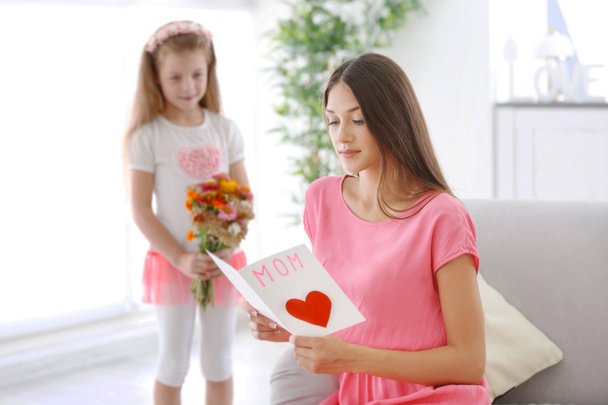 daughter with flowers greeting mother at home, Mothers day concept - Fotoğraf, Görsel