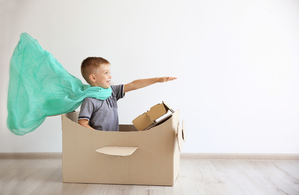 Niño jugando con el avión de cartón
  - Foto, Imagen