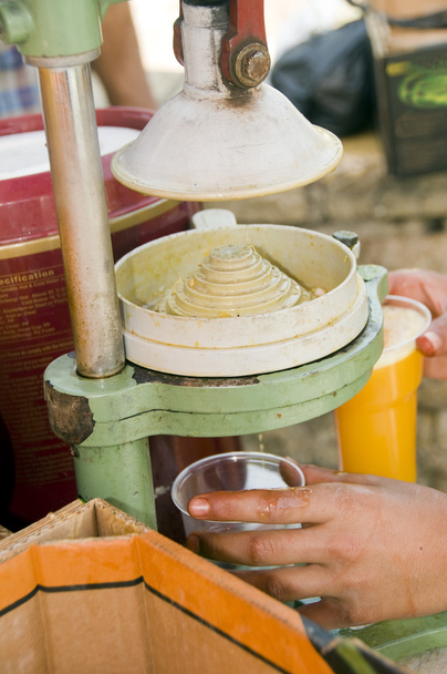 trabajador exprimiendo jugo de naranja fresca antigua prensa de jugo ma
 - Foto, Imagen