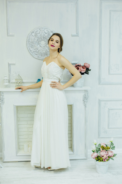 Young bride near the white fireplace. - Photo, Image