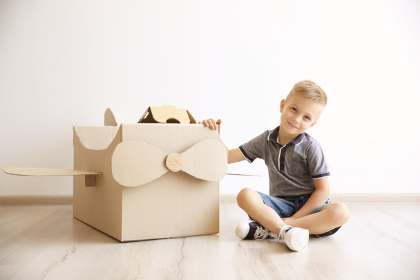 Little boy playing with cardboard airplane  - 写真・画像