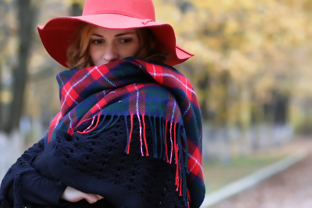 Vakava nainen punainen hattu syksyllä puistossa
 - Valokuva, kuva