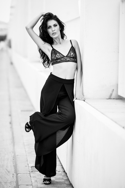 Brunette woman wearing black bra and trousers - Foto, Imagen