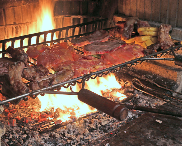 gorący ogień, gotować pyszne pikantne kiełbasy i żeberka wieprzowe z grilla - Zdjęcie, obraz