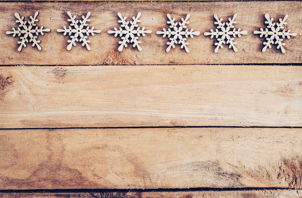 Рождественское украшение с деревянной снежинкой на столе с копировальным спаком
 - Фото, изображение