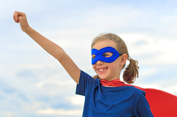 Smiling superhero kid against blue sky background. - Photo, Image