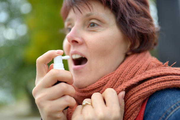 mladá žena pomocí krční spreje - Fotografie, Obrázek